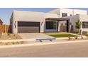 Modern home with clean lines, a dark brown garage door, and low maintenance desert landscaping at 10230 E Utah Ave, Mesa, AZ 85212