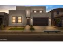 Modern two-story home featuring a minimalist design, well-lit exterior, and a two-car garage at 10236 E Utah Ave, Mesa, AZ 85212