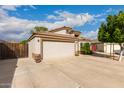 Traditional-style single-story home features a concrete driveway, tan stucco, and a two-car garage with direct entry at 1043 N 90Th Cir, Mesa, AZ 85207