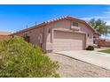 Single-story home with a two-car garage, desert landscaping, and a well-maintained driveway at 11266 E Dartmouth Cir, Mesa, AZ 85207
