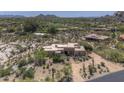 An aerial view showcases the property's desert landscape, including lush greenery and a circular driveway at 1401 E Boulder Pass Pass, Carefree, AZ 85377