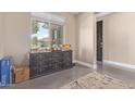 Entryway with a decorative chest of drawers under a window and dark paneled door at 15812 W Lisbon Ln, Surprise, AZ 85379