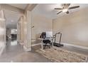 Office space with a desk, office chair, and treadmill under a ceiling fan with drop lighting at 15812 W Lisbon Ln, Surprise, AZ 85379