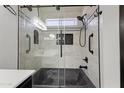 Modern bathroom with glass-enclosed shower, black fixtures, and decorative tile accents at 16235 W Cottonwood St, Surprise, AZ 85374