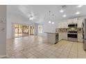 Bright, open-concept kitchen and living area with tile flooring, stainless steel appliances, and access to the backyard at 16235 W Cottonwood St, Surprise, AZ 85374