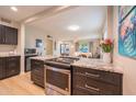 View of kitchen and into the living room with stove with granite counters in foreground at 1644 W Roma Ave, Phoenix, AZ 85015