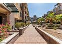 Beautifully landscaped courtyard with brick walkways, planter beds, and lush greenery at 17 W Vernon Ave # 121, Phoenix, AZ 85003