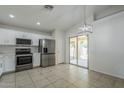 Bright kitchen with stainless appliances, white cabinets, and an open layout to the backyard at 17953 N Lettere Cir, Maricopa, AZ 85138