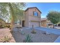 Two-story home showcasing desert landscaping and a well-manicured front yard at 18586 N Lariat Rd, Maricopa, AZ 85138