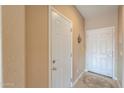 Neutral-colored hallway featuring tile flooring and white doors at 18586 N Lariat Rd, Maricopa, AZ 85138
