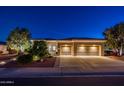 Exterior view showcasing a spacious three-car garage with an expansive driveway and lush landscaping at 22208 N San Ramon Dr, Sun City West, AZ 85375