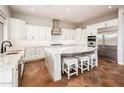 Bright kitchen with white cabinetry, an island with seating, and modern appliances at 22208 N San Ramon Dr, Sun City West, AZ 85375