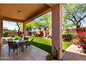 Inviting covered patio with tile flooring and outdoor dining area, overlooking a lush backyard at 22232 N 48Th St, Phoenix, AZ 85054