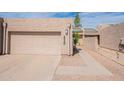 Beige home featuring a private garage and neutral-toned desert landscape with a paved driveway at 2320 S Forest Ave, Tempe, AZ 85282