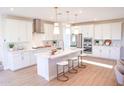 Bright, modern kitchen featuring white cabinetry, stainless steel appliances, and center island with seating at 2480 W Rowel Rd, Phoenix, AZ 85085