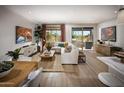 Bright living room with white sofa, stylish decor, and sliding glass doors to outdoor patio with grill at 2480 W Rowel Rd, Phoenix, AZ 85085