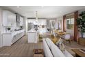 Spacious living room and kitchen area with white cabinets, stainless steel appliances and wood flooring at 2480 W Rowel Rd, Phoenix, AZ 85085