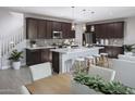 A modern kitchen with dark cabinets, a center island, and stainless steel appliances at 2486 W Rowel Rd, Phoenix, AZ 85085