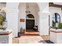 Inviting front entryway showcasing a decorative chandelier, elegant double doors, and textured stucco walls at 3209 E Fox St, Mesa, AZ 85213