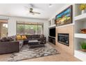 Comfortable living room with a fireplace and a large window overlooking the backyard at 41202 N Rolling Green Way, Anthem, AZ 85086