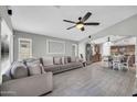 Open concept living space with a large sofa, wood-look tile floors, and view to the kitchen at 4232 S 103Rd Ln, Tolleson, AZ 85353