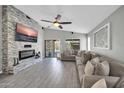 Inviting living room with a stone fireplace, ceiling fan, and large sectional sofa at 4232 S 103Rd Ln, Tolleson, AZ 85353