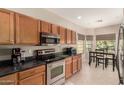 Functional kitchen featuring wood cabinets, stainless steel appliances, and a cozy breakfast nook at 45028 W Cypress Ln, Maricopa, AZ 85139
