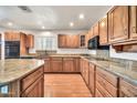Spacious kitchen with a center island, granite countertops, and wooden cabinets at 5126 W Las Palmaritas Dr, Glendale, AZ 85302