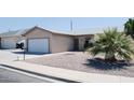 Cozy home featuring a xeriscaped front yard with a charming palm tree at 749 N 99Th St, Mesa, AZ 85207