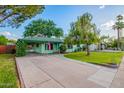 Charming home features a well-manicured lawn, mature trees, and long driveway at 811 W Ocotillo Rd, Phoenix, AZ 85013