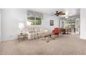 Cozy living room featuring neutral carpet, a ceiling fan, and a view of the yard at 811 W Ocotillo Rd, Phoenix, AZ 85013