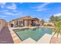 Beautiful backyard with a sparkling pool, covered patio, and ample space for outdoor living and entertaining at 8420 W Cherry Hills Dr, Peoria, AZ 85345