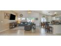 Open-concept living space featuring tile floors, vaulted ceilings, and a seamless transition to the dining area at 8420 W Cherry Hills Dr, Peoria, AZ 85345