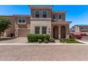 Two-story home with brick driveway, stucco and stone exterior, paired garage, and landscaped front yard at 9733 E Axle Ave, Mesa, AZ 85212