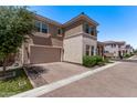 Side angle view of the two-car garage of this house, complete with a brick driveway and lush front yard greenery at 9733 E Axle Ave, Mesa, AZ 85212