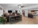 Open-concept living room with tile floors, ceiling fans, and barstool seating at 10532 W Catalina Dr, Avondale, AZ 85392