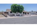 Single-story home with white brick and well manicured tree in front yard at 10609 N 32Nd Cir, Phoenix, AZ 85029