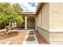 Inviting front porch with sitting area, iron gate, and walkway to the home's entrance at 14205 N 136Th Ln, Surprise, AZ 85379