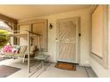 Relaxing front porch with swing and secure front door featuring decorative security screen at 14205 N 136Th Ln, Surprise, AZ 85379
