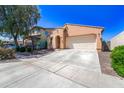 Single-Gathering home with a two-car garage, light stucco and landscaped front yard with mature trees on a sunny day at 14916 W Georgia Dr, Surprise, AZ 85379