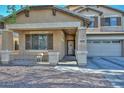 View of the front of the home showcasing the cozy covered porch and a view of the two-car garage at 16112 W Durango St, Goodyear, AZ 85338