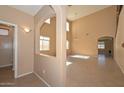 View of the main living area with an arched entry, soaring ceilings, and tile flooring and natural light at 16112 W Durango St, Goodyear, AZ 85338