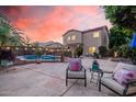 Beautiful backyard with a pool, patio furniture, pavers, and string lights, perfect for outdoor entertaining at 16153 W Lisbon Ln, Surprise, AZ 85379