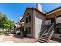 Inviting condo exterior showcasing stucco walls, red tile roof, and wrought iron stair rails at 19820 N 13Th Ave # 255, Phoenix, AZ 85027