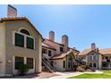 Attractive condo complex features red tile roofs and wrought iron staircases surrounded by lush landscaping at 19820 N 13Th Ave # 255, Phoenix, AZ 85027