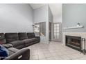 Spacious living room with a comfortable gray sofa, tile floors, fireplace and bright window at 19820 N 13Th Ave # 255, Phoenix, AZ 85027