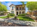 Inviting two-story home featuring a charming balcony, manicured lawn, and traditional architectural details at 21104 W Sage Hill Rd, Buckeye, AZ 85396