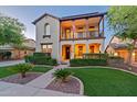 Charming two-story home boasting a welcoming front yard with lush landscaping and a second story balcony at 21104 W Sage Hill Rd, Buckeye, AZ 85396