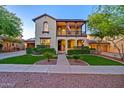 Charming two-story home boasting a welcoming front yard with lush landscaping and a second story balcony at 21104 W Sage Hill Rd, Buckeye, AZ 85396