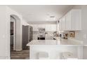 Modern kitchen featuring white cabinets, stainless steel appliances, light countertops and an island at 21972 W Pima St, Buckeye, AZ 85326